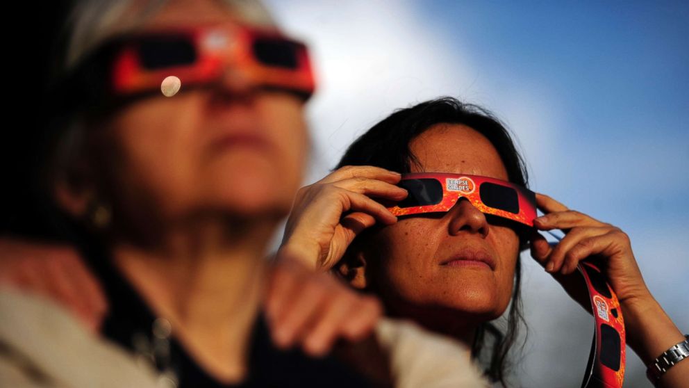 PHOTO: Ina Schakaraschwili holds her glasses in place during a solar eclipse at the University of Denver's Chamberlain Observatory in this May 20, 2012 file photo