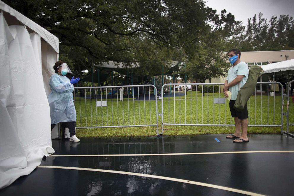 PHOTO: Dr. Jacqueline Delmont, Chief Medical Officer of SOMOS Community Care, asks Eddie Mena to move forward into the medical tent to be tested for COVID-19 at a testing site, July 22, 2020, in Miami Lakes, Fla.