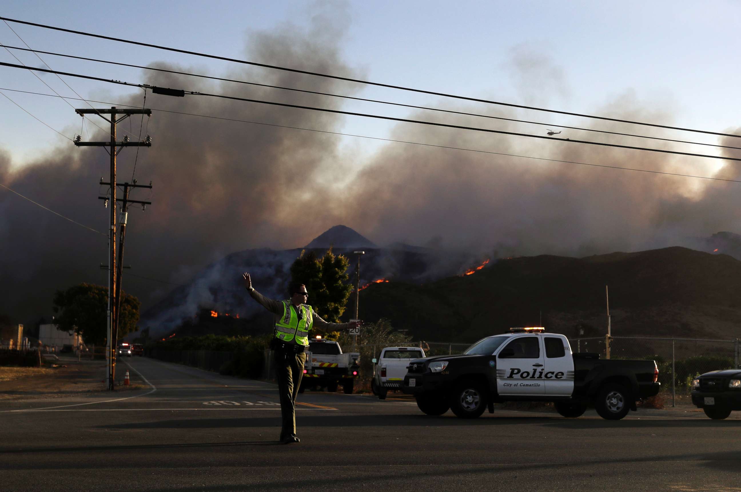 PHOTO: A police officer mans a checkpoint in front of an advancing wildfire Thursday, Nov. 8, 2018, near Newbury Park, Calif.