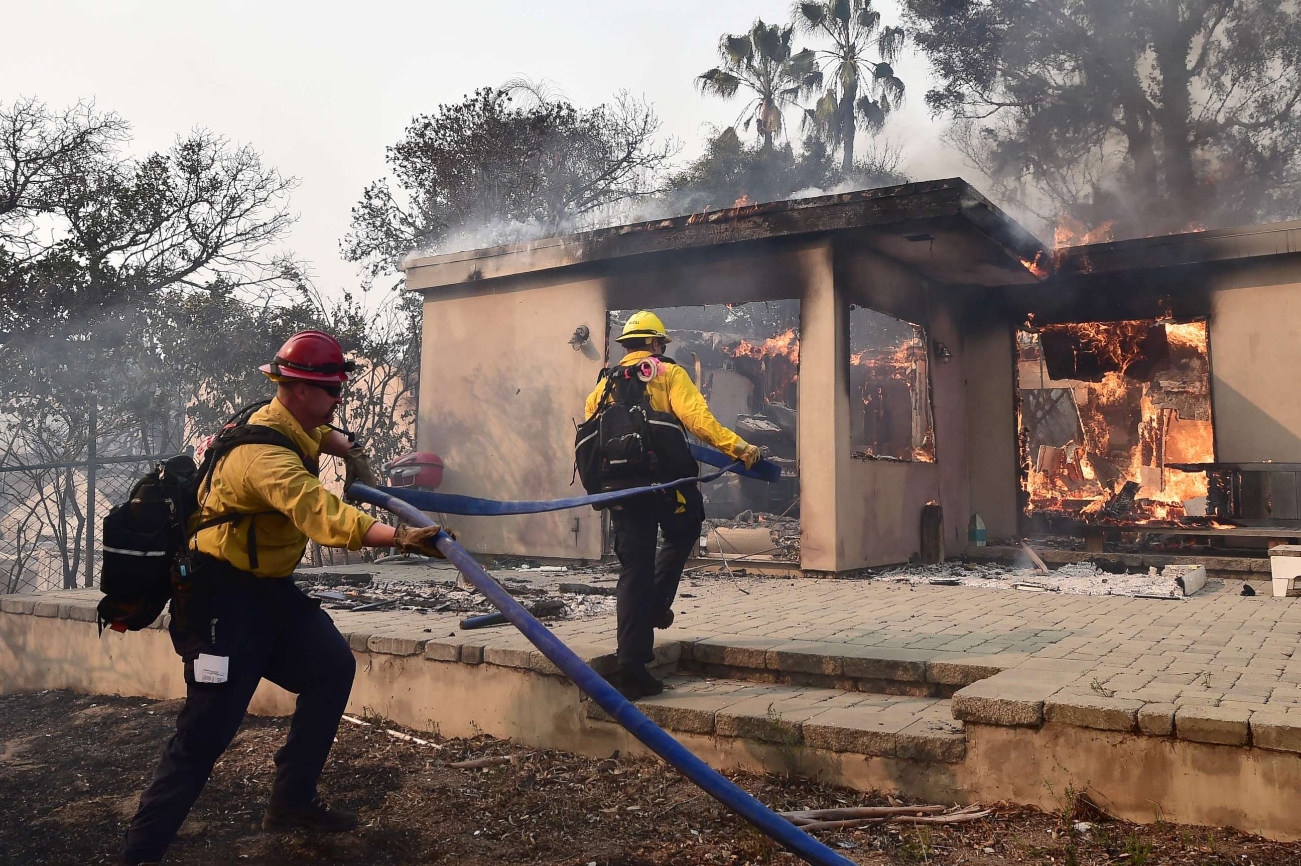 PHOTO: Firefighters knock down flames in the Point Dume neighborhood of Malibu, Calif., on Nov. 10, 2018, after the Woolsey Fire tore through the neighborhood overnight.