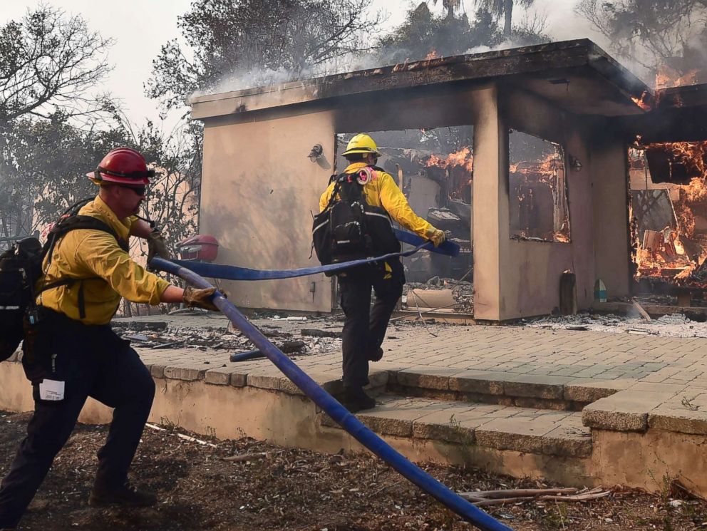 PHOTO: Firefighters extinguish the flames in the Point Dume neighborhood in Malibu, California on November 10, 2018, after the Woolsey fire devastated the neighborhood during the night.