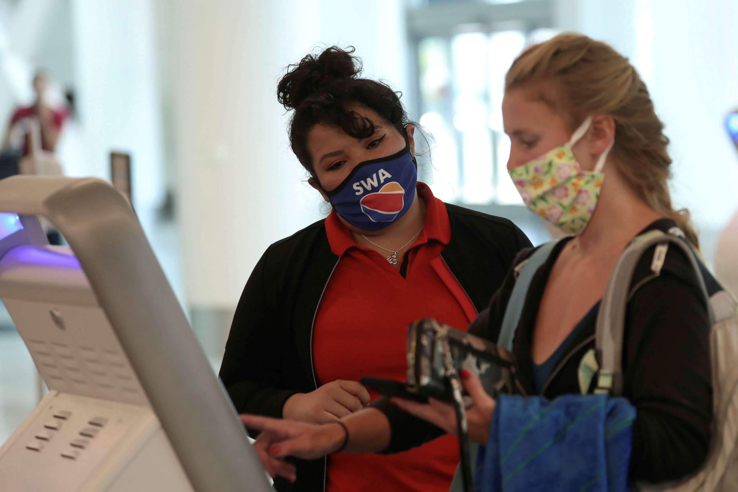 FILE PHOTO: A Southwest Airlines Co. employee wears a protective mask while assisting a passenger at Los Angeles International Airport (LAX) during the outbreak of the coronavirus disease (COVID-19) in Los Angeles, California, U.S., May 23, 2020. 