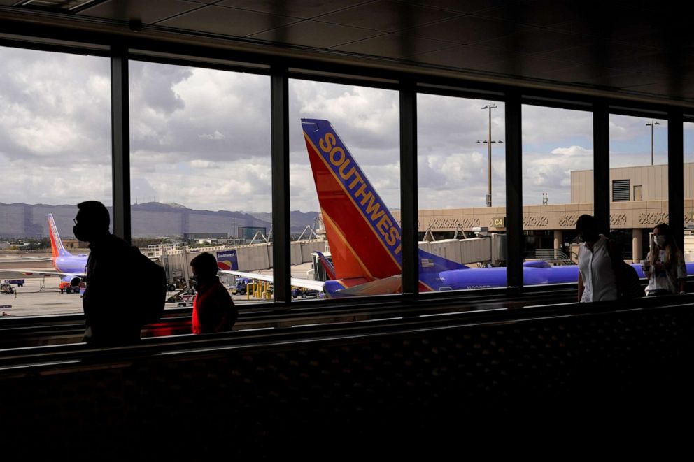 PHOTO: Passengers walk past a Southwest Airlines plane at Sky Harbor International Airport in Phoenix, March 26, 2021.