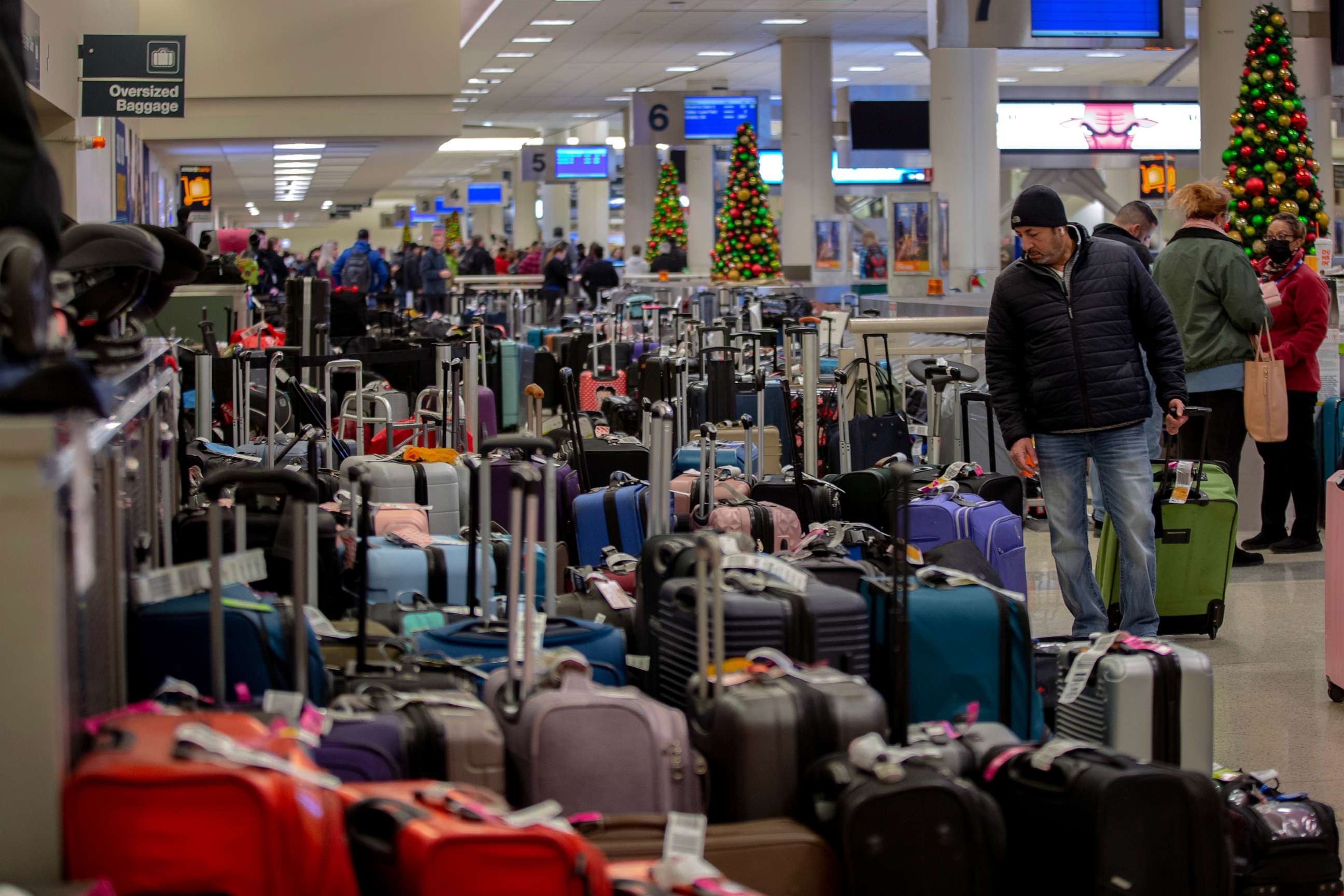 PHOTO: Stranded travelers search for their luggage at the Southwest Airlines Baggage Claim at Midway Airport on Dec. 27, 2022 in Chicago.