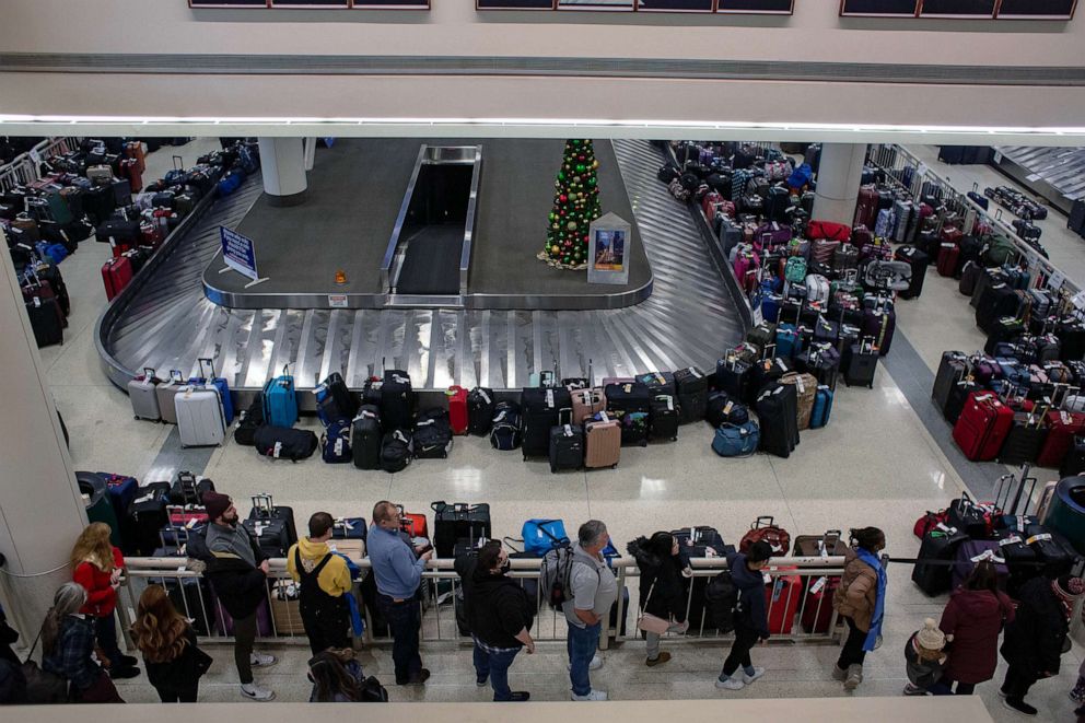 PHOTO: Stranded travelers search for their luggage at the Southwest Airlines Baggage Claim at Midway Airport, Dec. 27, 2022 in Chicago.