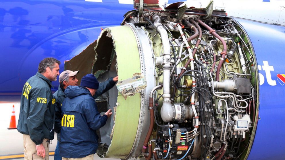 National Transportation Safety Board investigators examine damage to the engine of the Southwest Airlines plane that made an emergency landing at Philadelphia International Airport in Philadelphia on Tuesday.