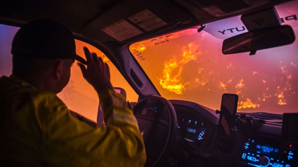 PHOTO: Cal Fire battalion chief and strike team leader Gino DeGraffenreid drives past a flaming hillside while checking on homes Monday night in Toro Canyon, Calif. at the Thomas Fire on Dec. 11, 2017.