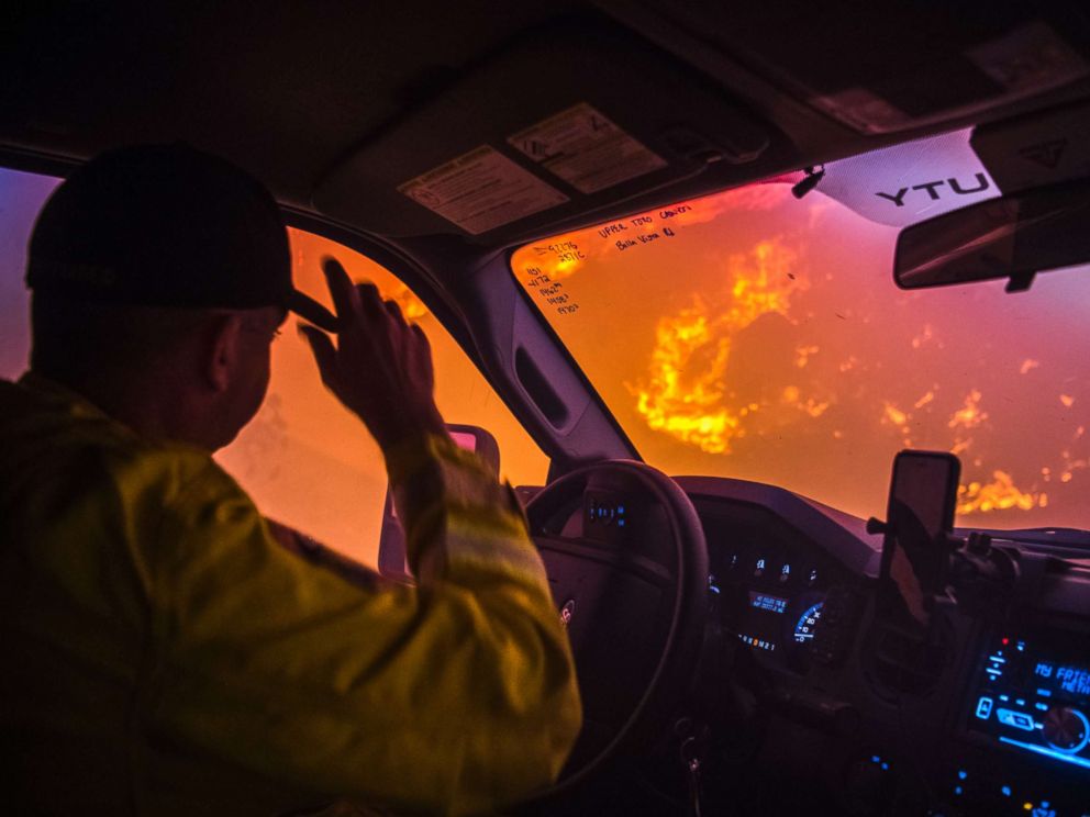 PHOTO: Cal Fire battalion chief and strike team leader Gino DeGraffenreid drives past a flaming hillside while checking on homes Monday night in Toro Canyon, Calif. at the Thomas Fire on Dec. 11, 2017.