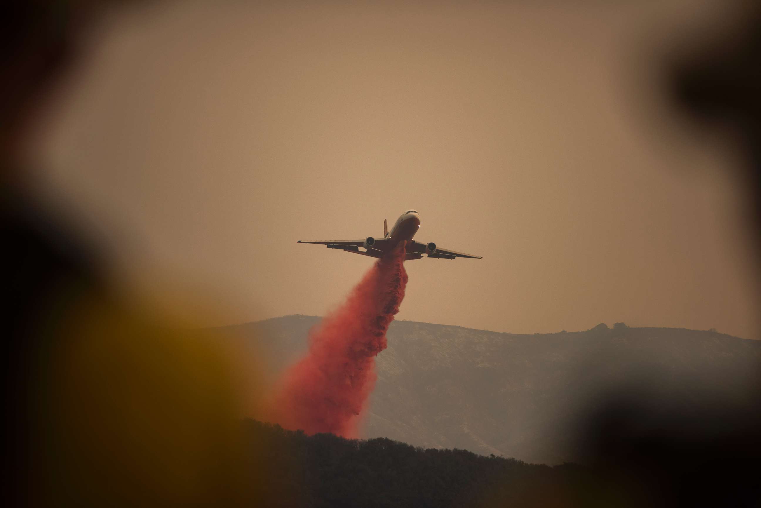 PHOTO: A DC-10 jet, or VLAT (Very Larger Air Tanker) drops fire retardant in Toro Canyon, Calif. on Monday afternoon, Dec. 11, 2017, before anticipated winds caused the fire to burn downhill. 