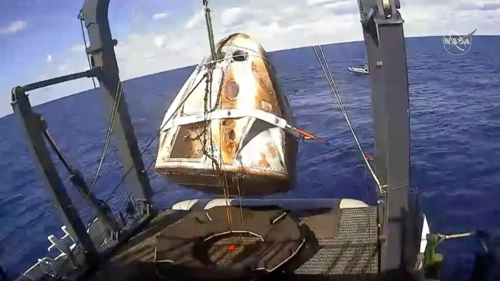 PHOTO: In this image from video made available by NASA, the SpaceX Crew Dragon capsule is hoisted onto a ship in the Atlantic Ocean off the Florida coast after it returned from a mission to the International Space Station, March 8, 2019.