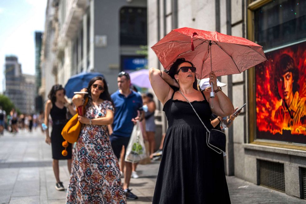PHOTO: A woman holds an umbrella to shelter from the sun during a hot sunny day in Madrid, July 18, 2022.