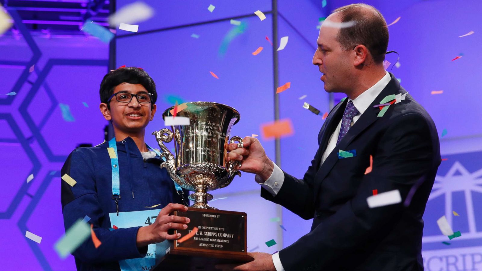 PHOTO: Karthik Nemmani, 14, from McKinney, Texas, left, holds his trophy with President and CEO of the E.W. Scripps Company Adam Symson as confetti falls after winning the Scripps National Spelling Bee in Oxon Hill, Md., May 31, 2018.