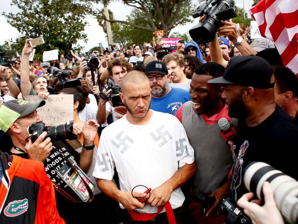 PHOTO: A man wearing a shirt with swastikas is forced away from the scene by the crowd near the site of a planned speech by white nationalist Richard Spencer at the University of Florida campus, Oct. 19, 2017, in Gainesville, Florida.