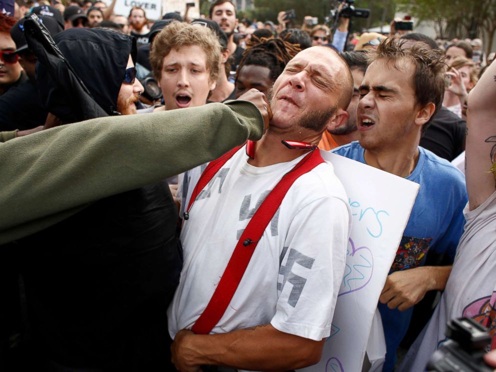 PHOTO: A man wearing a shirt with swastikas on it is punched by an unidentified member of the crowd near the site of a planned speech by white nationalist Richard Spencer at the University of Florida campus, Oct. 19, 2017, in Gainesville, Florida.