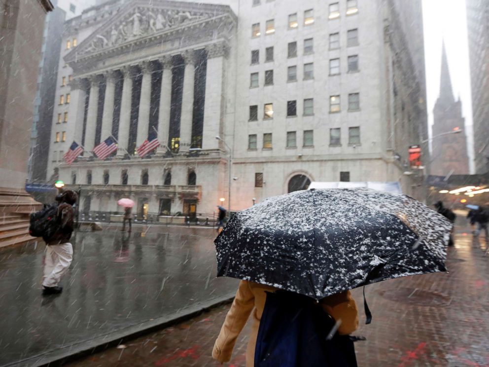 FOTO: Komuter pagi berjalan melewati salju di luar Bursa Efek New York, pada 2 April 2018.