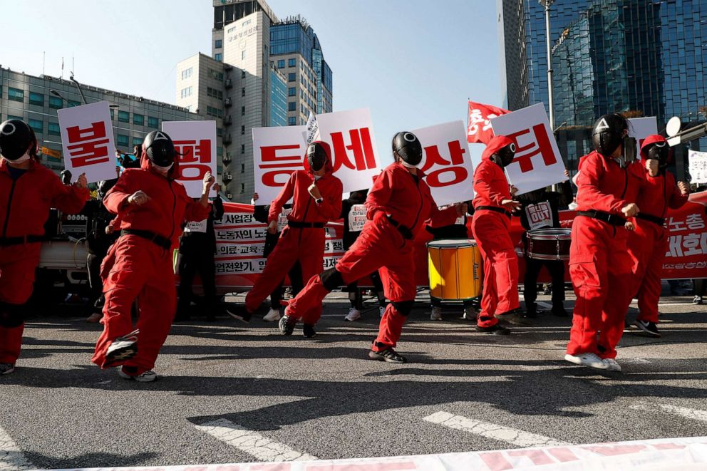 PHOTO: Members of the South Korean Confederation of Trade Unions (KCTU) wear masks inspired by the South Korean television series 'Squid Game' at a rally against the government's labor policy in Seoul, Oct. 2021.