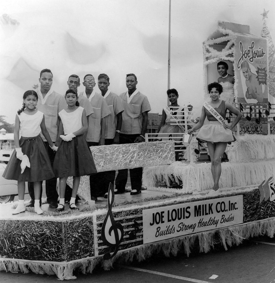 PHOTO: Representatives of the Joe Louis Milk Company ride atop their float, during the annual Bud Billiken Day parade, in Chicago, in 1958. 