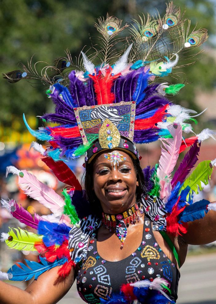 PHOTO: A woman bedecked in feathers marches in the annual Bud Billiken Parade in Chicago, on Aug. 10, 2019.