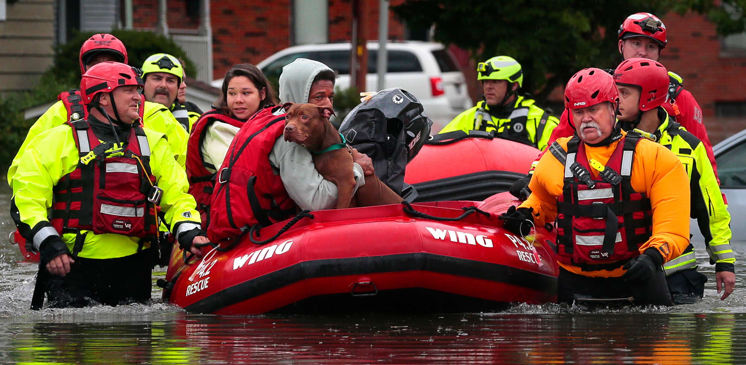 PHOTO: Matthew Robinson holds onto his dog Bebe as and Kimberly Tat are rescued from their home by first responders from Central County Fire and Rescue along Main Street in Old Towne St. Peters, Mo., on Tuesday, July 26, 2022.