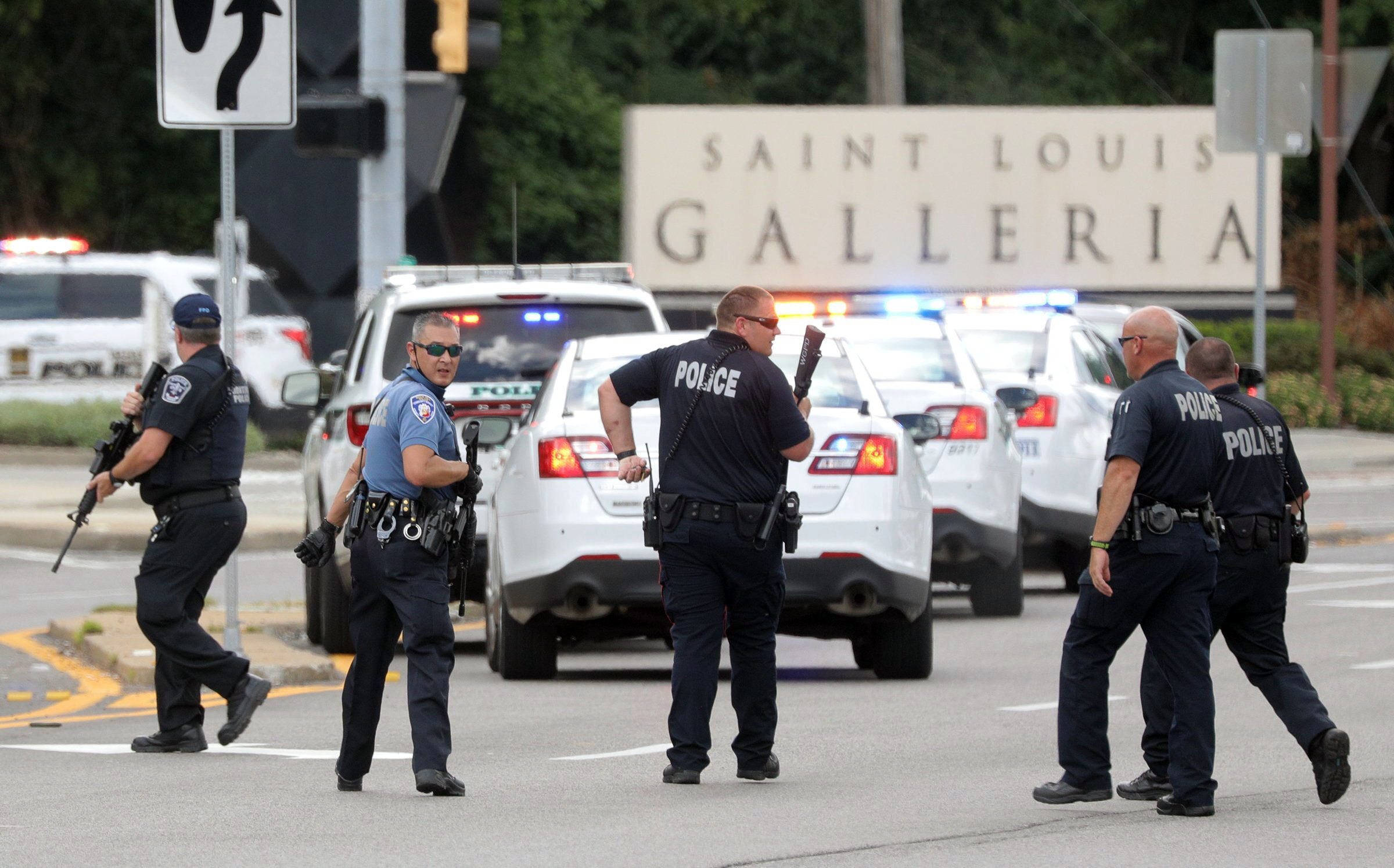 PHOTO: Police with their guns drawn search along Brentwood Boulevard near the St. Louis Galleria looking for a suspect in the reported shooting at the mall in the town of Richmond Heights near St. Louis, July 22, 2020.