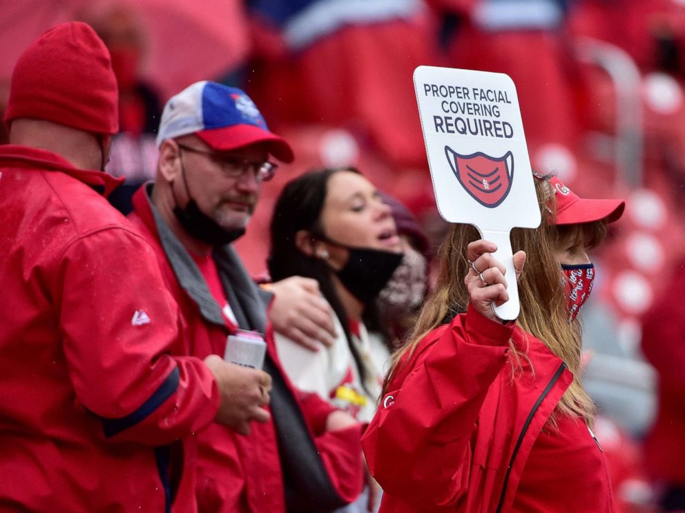 PHOTO:  An usher walks through the aisles and carries a sign reminding fans to wear their mask during the seventh inning of the home opener against the Milwaukee Brewers at Busch Stadium in St Louis, Mo., April 8, 2021.