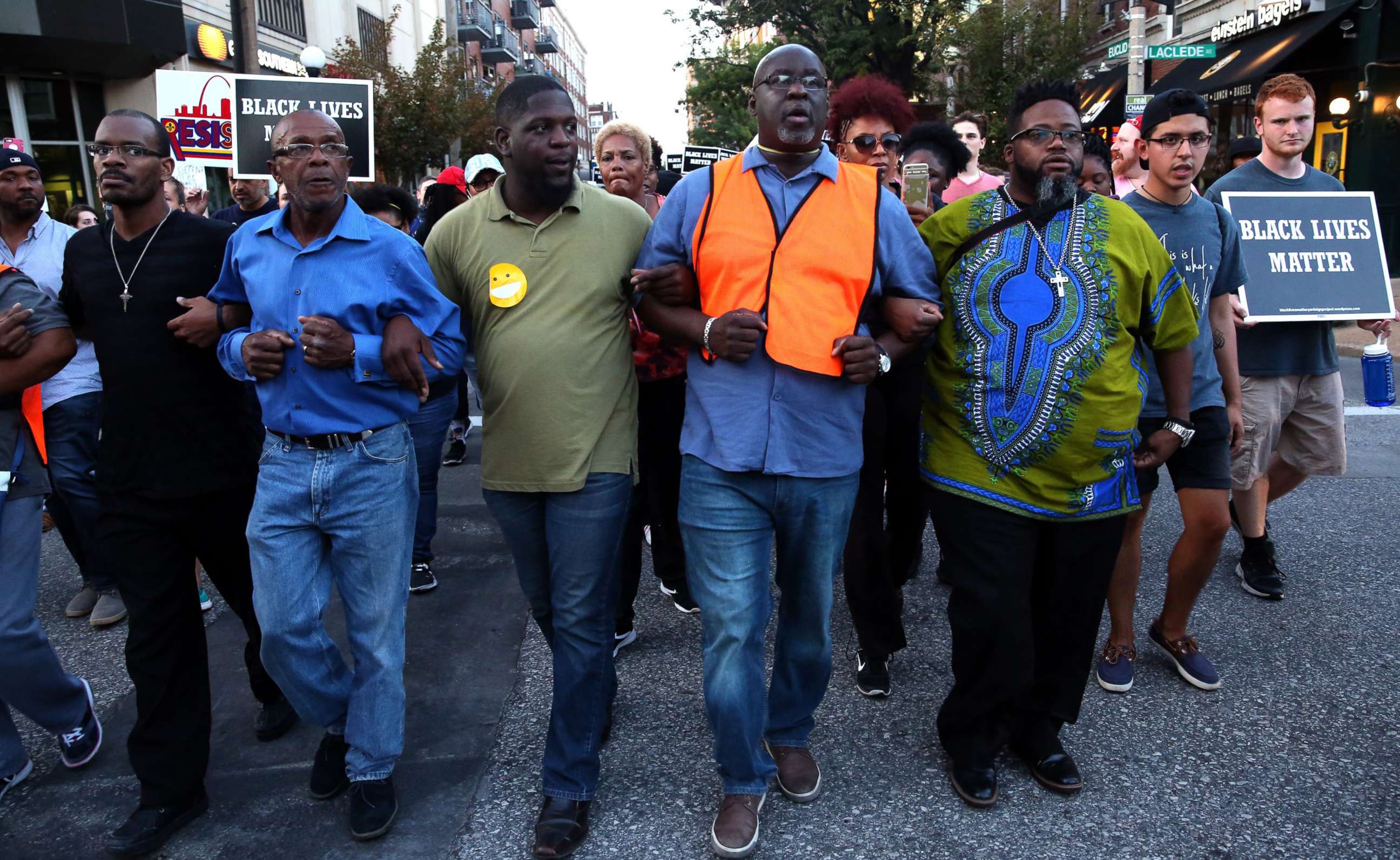 PHOTO: Pastor Clinton Stancil, center right, of Wayman AME Church locks arms with fellow clergy members as they lead hundreds of people protesting down Euclid Avenue, Sept. 15, 2017, in the Central West End.