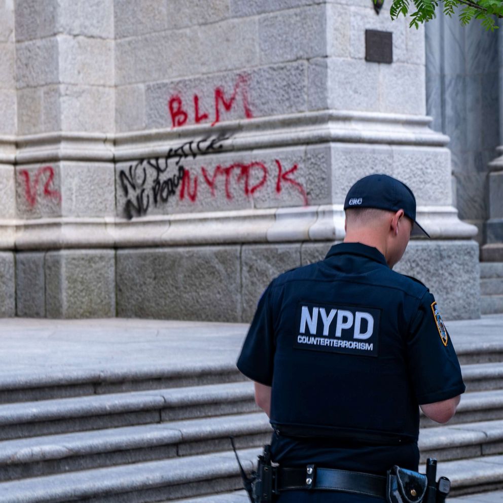 PHOTO: A NYPD officer walks by a vandalized St. Patrick's Cathedral on May 30, 2020 in New York City.