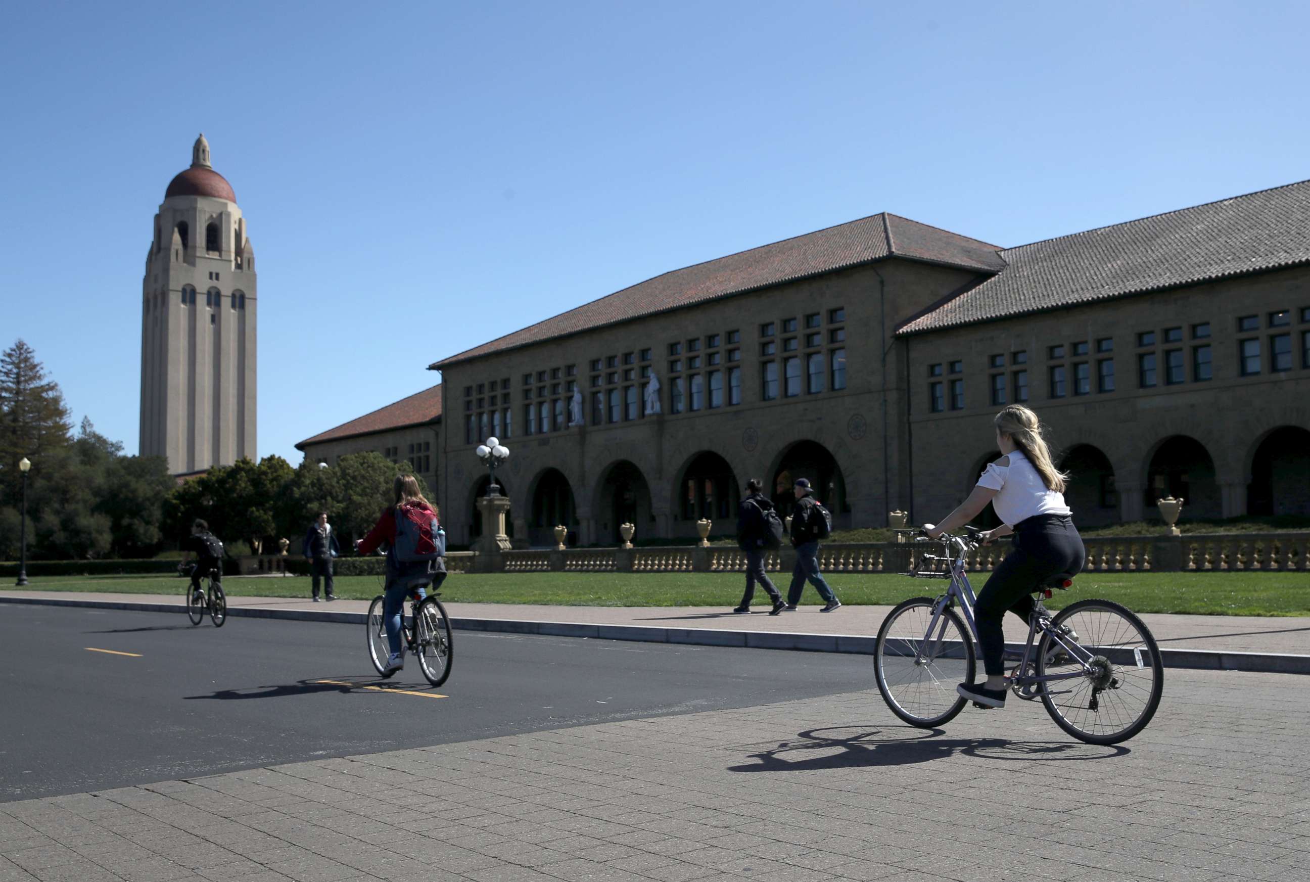 PHOTO: Cyclists ride by Hoover Tower on the Stanford University campus on March 12, 2019 in Stanford, California.