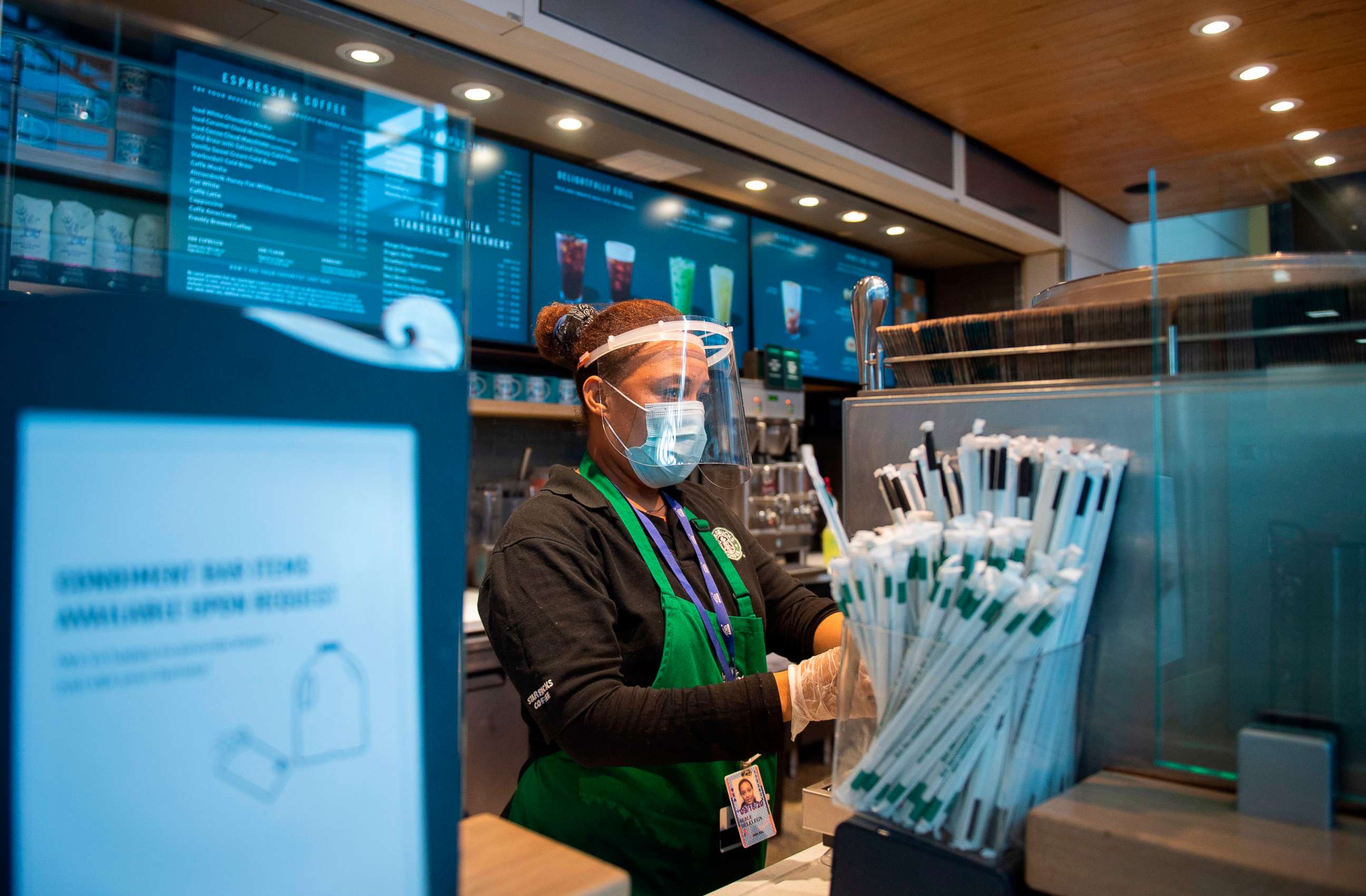 PHOTO: A Starbucks employee wears a face shield and mask as she makes a coffee in Ronald Reagan Washington National Airport in Arlington, Virginia, on May 12, 2020.
