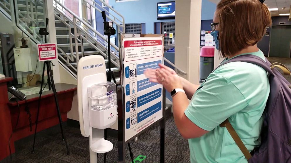 PHOTO: Hand sanitizer and signage that includes a list of COVID-19 symptoms are placed at each entrance.