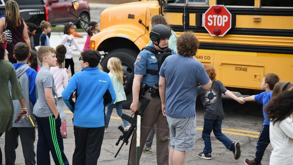 PHOTO: Students are escorted to a school bus in front of STEM School Highlands Ranch after a shooting, May 7, 2019, in  Highlands Ranch, Colo. 
