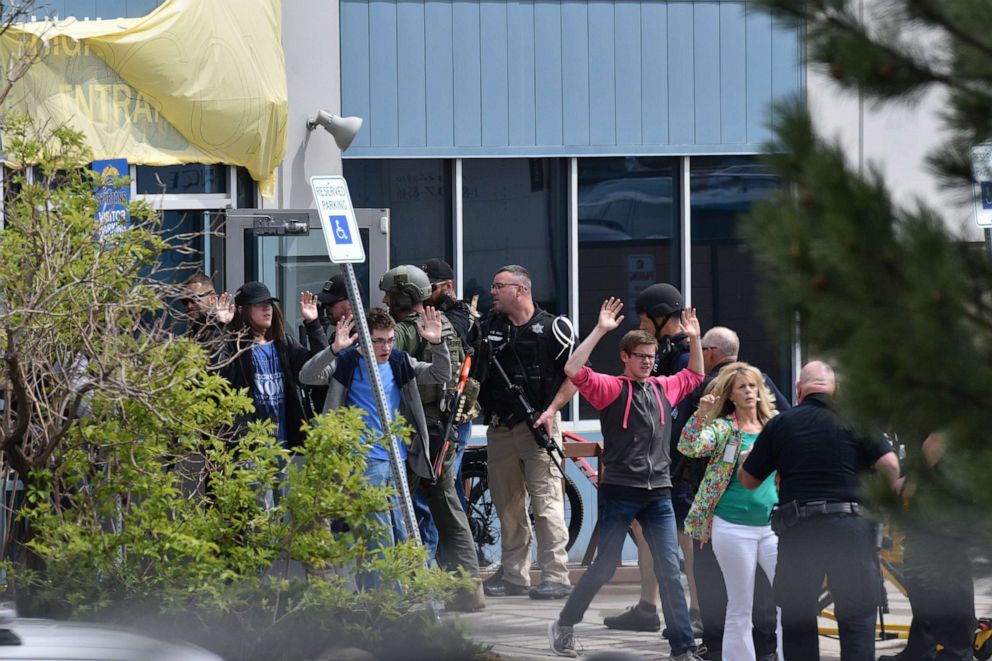 PHOTO: Students and teachers raise their arms as the exit the scene of a shooting in which one person was killed and eight were injured at the STEM School Highlands Ranch on May 7, 2019, in Highlands Ranch, Colo.