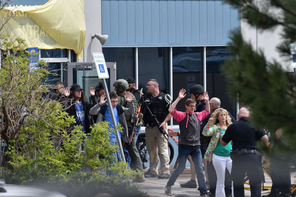 PHOTO: Students and teachers raise their arms as they exit the scene of a shooting in which at least seven students were injured at the STEM School Highlands Ranch on May 7, 2019, in Highlands Ranch, Colorado.
