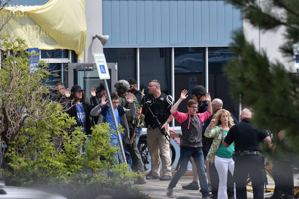 PHOTO: Students and teachers raise their arms as they exit the scene of a shooting in which at least seven students were injured at the STEM School Highlands Ranch on May 7, 2019, in Highlands Ranch, Colo.