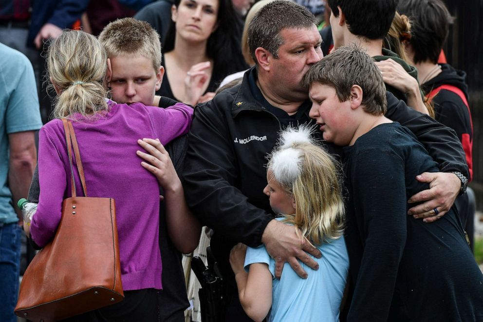 PHOTO: A police officer hugs his kids after they were evacuated to the Recreation Center at Northridge after at least seven students were injured during a shooting at STEM School Highlands Ranch on May 7, 2019, in Highlands Ranch, Colorado.