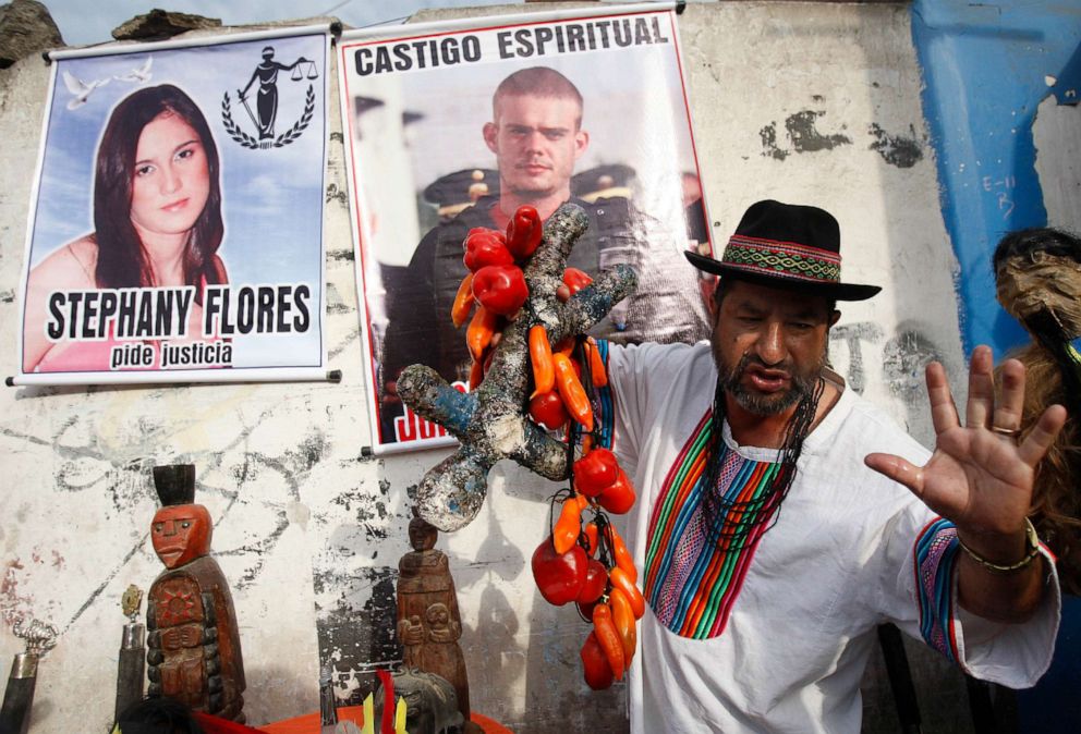 FOTO: Un chamán realiza un ritual por el castigo espiritual de Joran van der Sloot, en la parte superior central del cartel, y por justicia para Stephany Flores, en el cartel de la izquierda, en Lima, Perú, el 6 de enero de 2012.