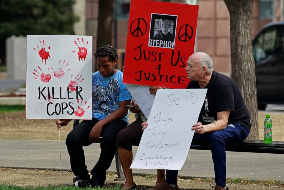 PHOTO: Demonstrators hold signs at a rally to protest the police shooting of Stephon Clark, in Sacramento, Calif., March 31, 2018.