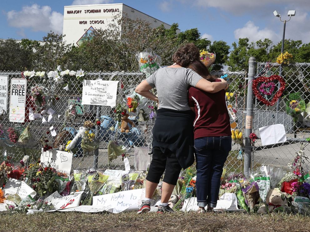 PHOTO: Joellen Berman, Guidance Data Specialist, and Margarita Lasalle, the budget keeper, look on at the memorial in front of Marjory Stoneman Douglas High School as teachers and staff are allowed to return to the school, Feb. 23, 2018, in Parkland, Fla.