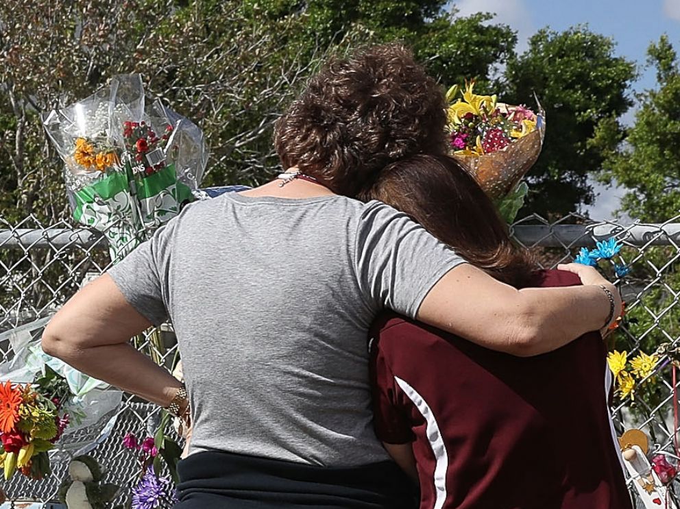 PHOTO: Joellen Berman, Guidance Data Specialist, and Margarita Lasalle, the budget keeper, look on at the memorial in front of Marjory Stoneman Douglas High School as teachers and staff are allowed to return to the school, Feb. 23, 2018, in Parkland, Fla.