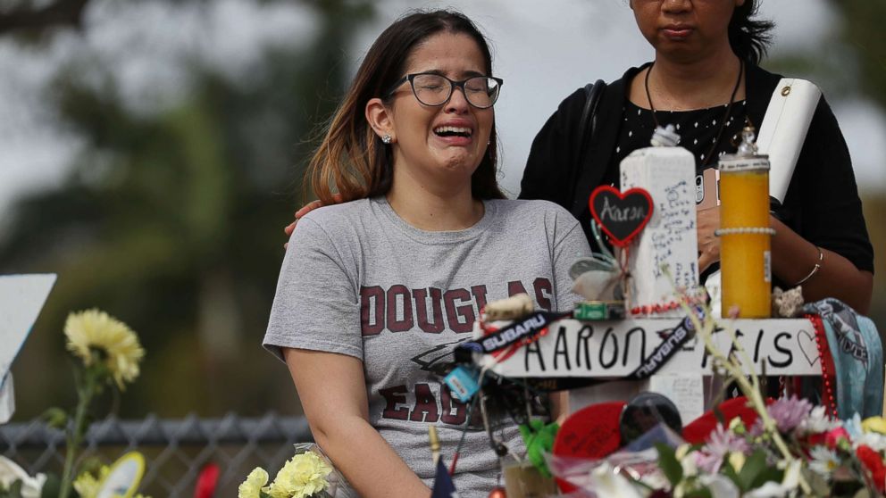 PHOTO: Ariana Gonzalez is over come with emotion as she visits a cross setup for her friend, football coach Aaron Feis, at the memorial in front of Marjory Stoneman Douglas High School, Feb. 23, 2018 in Parkland, Florida.