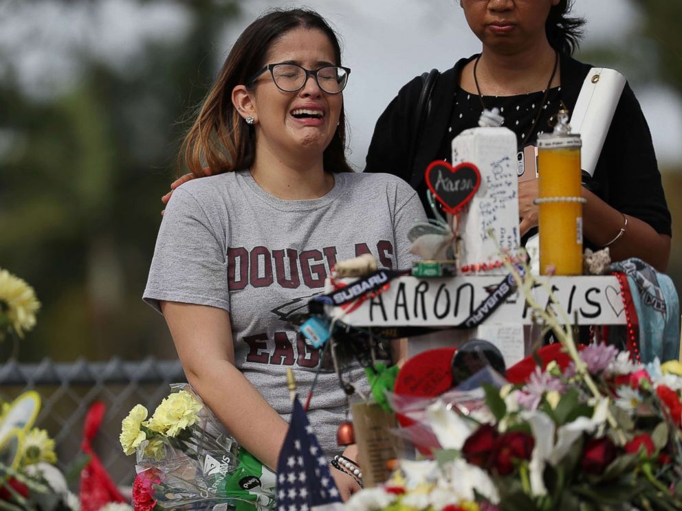PHOTO: Ariana Gonzalez is over come with emotion as she visits a cross setup for her friend, football coach Aaron Feis, at the memorial in front of Marjory Stoneman Douglas High School, Feb. 23, 2018 in Parkland, Florida.