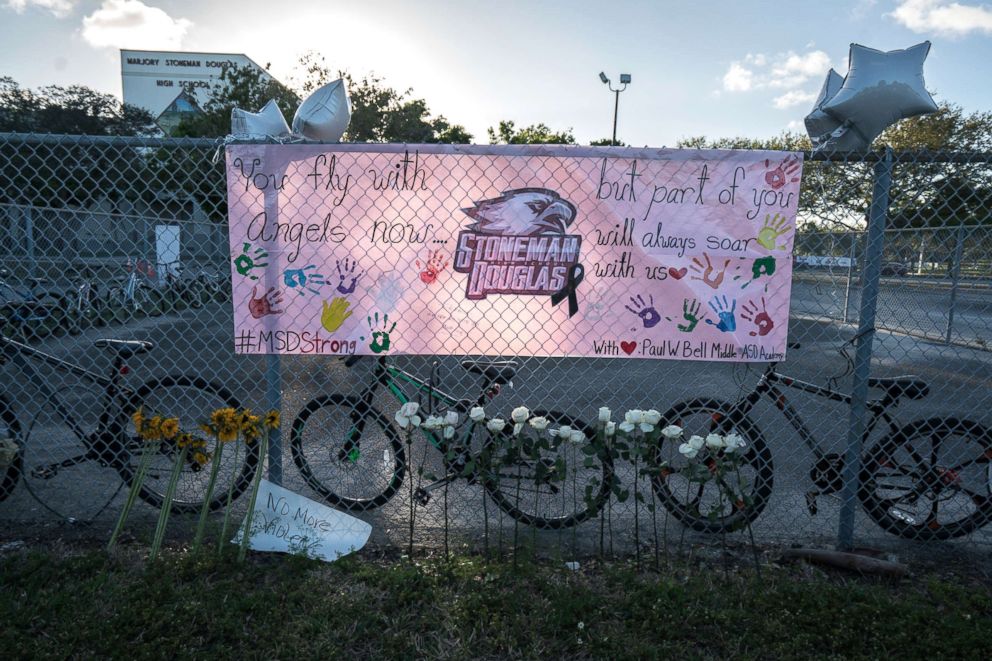 PHOTO: Signs and flowers are displayed by the fence surrounding Marjory Stoneman Douglas High School in Parkland, Fla., Feb. 25, 2018.