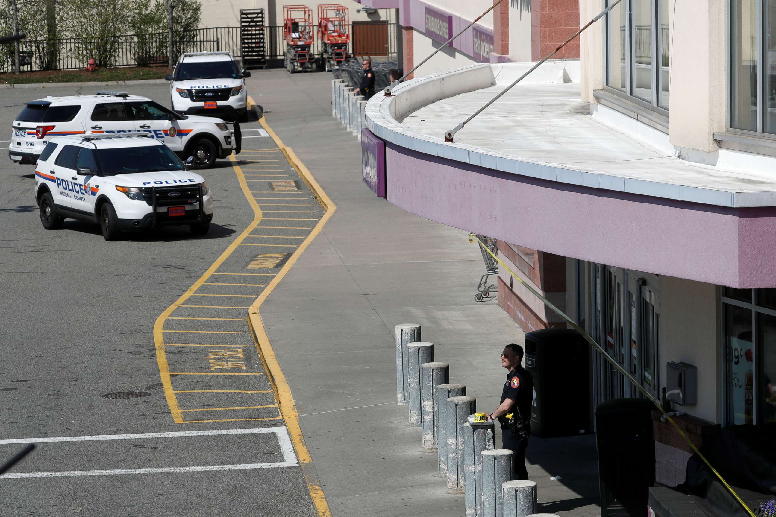 PHOTO: Law enforcement officers stand on the site of a shooting, at a Stop and Shop grocery store, in West Hempstead, N.Y., April 20, 2021.