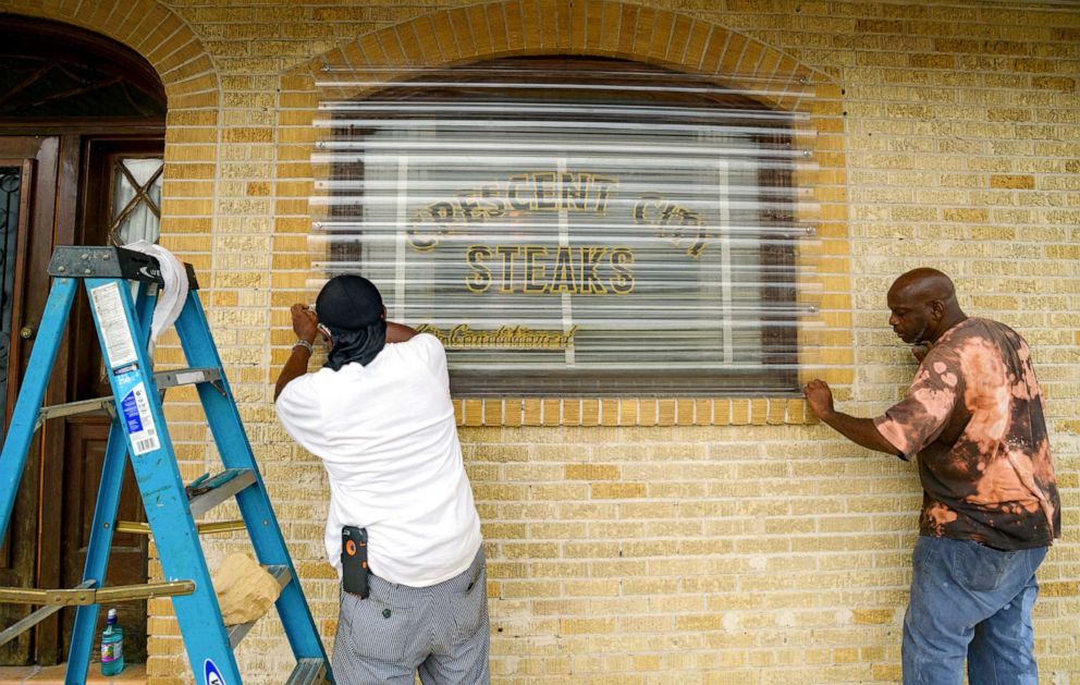 PHOTO: Employees of Crescent City Steaks screw in storm protectors over the windows before landfall of Tropical Storm Barry from the Gulf of Mexico in New Orleans, July 12, 2019.