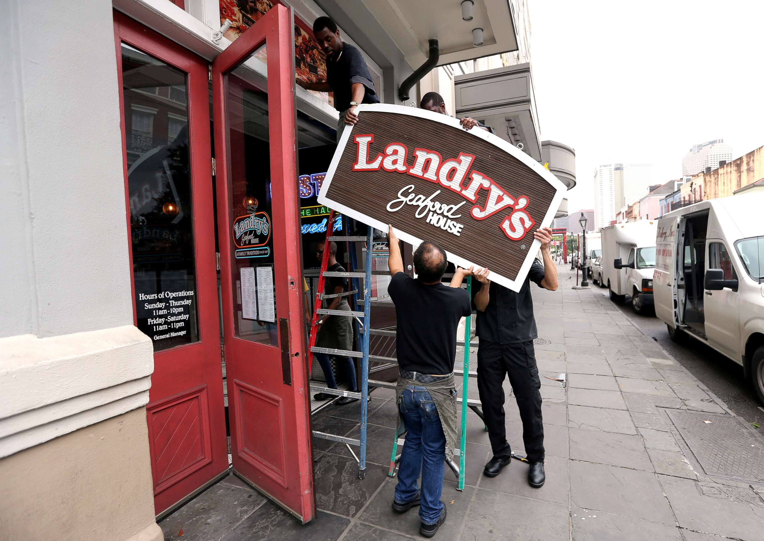 PHOTO: Employees remove a sign in the French Quarter as Tropical Storm Barry approaches land in New Orleans, July 12, 2019.