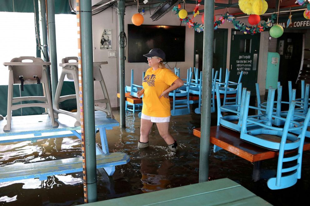 PHOTO:A woman walks through her flooded business during Hurricane Barry in Mandeville, Louisiana, July 13, 2019.