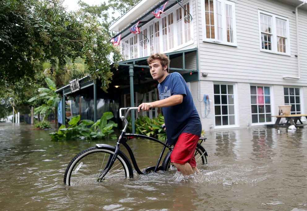 PHOTO: A man pushes his bike through a flooded street after Hurricane Barry in Mandeville, La., July 13, 2019.