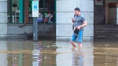 PHOTO: People cross the street as water floods outside buildings in Old Town Alexandria, Va., Sept. 11, 2018.