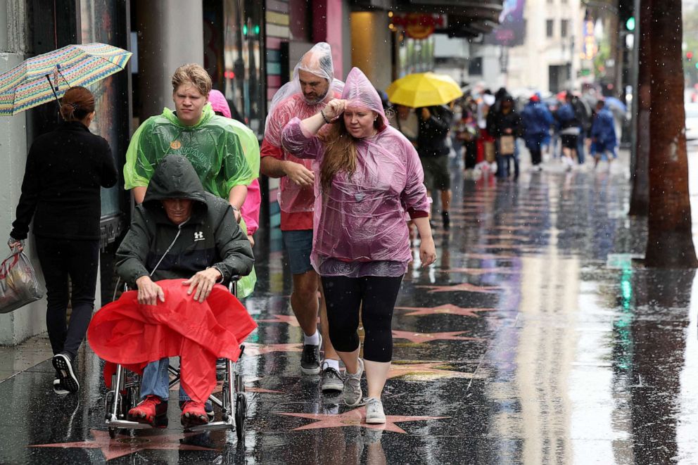 PHOTO: People walk along the Hollywood Walk of Fame during the tropical storm Hilary, in Los Angeles, Aug. 20, 2023.