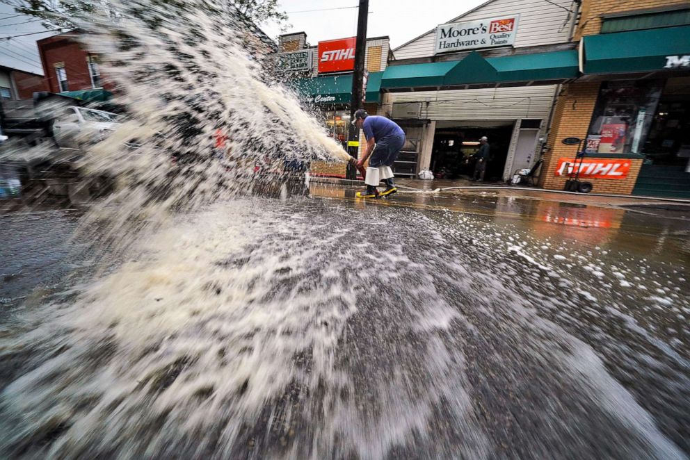 PHOTO: Water is pumped from the basement of a business on Noblestown road in Oakdale, Pa., during clean up from flooding after downpours and high winds from the remnants of Hurricane Ida, hit the area Sept. 1, 2021.